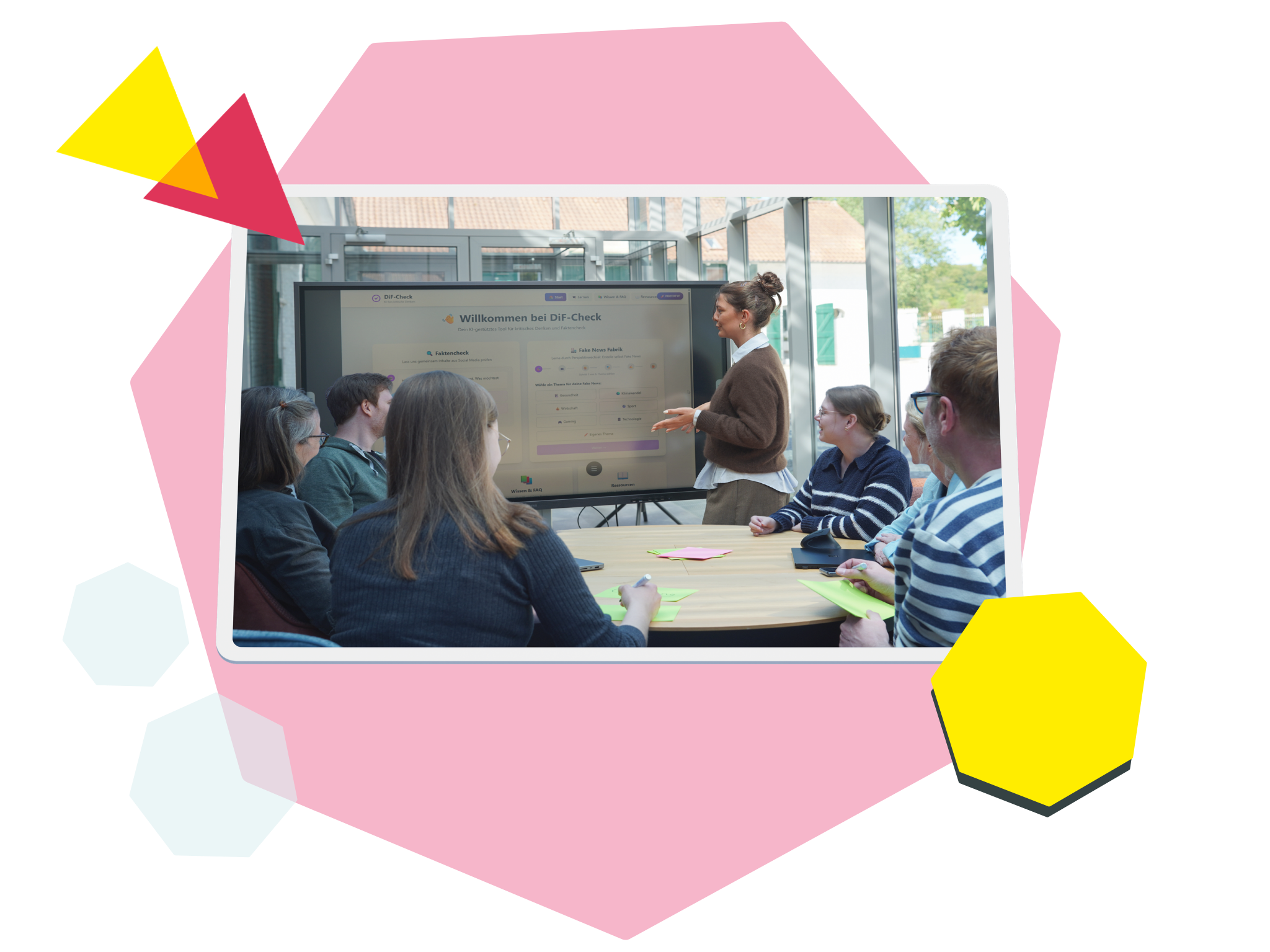 Das Bild zeigt einen Demokratie im Feed-Workshop: Eine Gruppe von Menschen sitzt um einen Tisch, eine Frau erklärt etwas an einem Bildschirm.